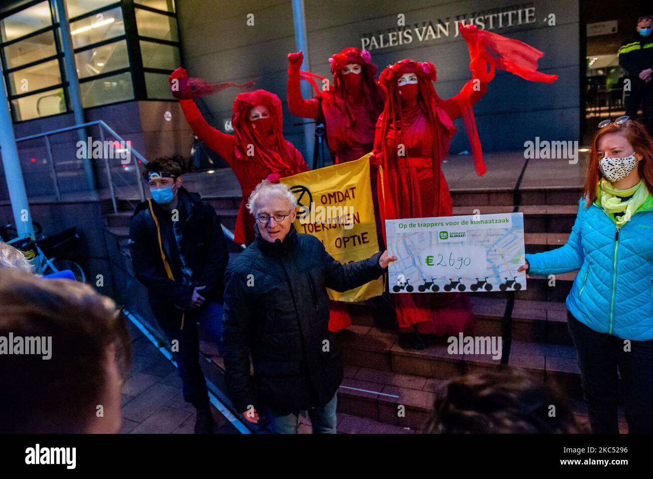 December 1st, The Hague. From Tuesday 1 December, Milieudefensie (Friends of the Earth Netherlands) will face Shell in court. The plaintiffs want Shell to take a more sustainable course. The full legal costs of €500,000 are covered by donations. The Red Rebels from Extinction Rebellion, and a group of climate activists that have been cycling from the North of the country in stages to draw attention to the climate case, delivered in front of the courts the donation check to the lawyer Roger Cox and his team. (Photo by Romy Arroyo Fernandez/NurPhoto) Stock Photo