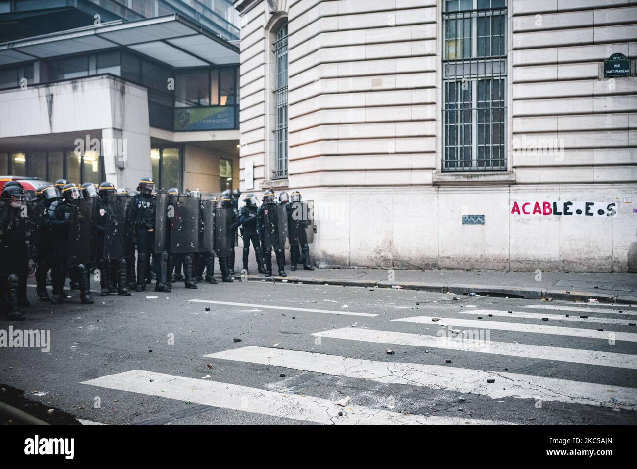 BRAV-M riot police officers form a security cordon next to a collage making a pun with 'ACAB' on 5 December 2020 as the third day of mobilisation against the so-called 'Global Security' bill was taking place in France. In Paris several thousand demonstrators gathered at Porte de Lilas to protest against article 24 banning the distribution of police images on social networks and article 23 on the use of drones by the police and facial recognition. Quickly Black Bloc took the lead of the demonstration and confronted the police making the demonstration never arrived at Place de la République wher Stock Photo