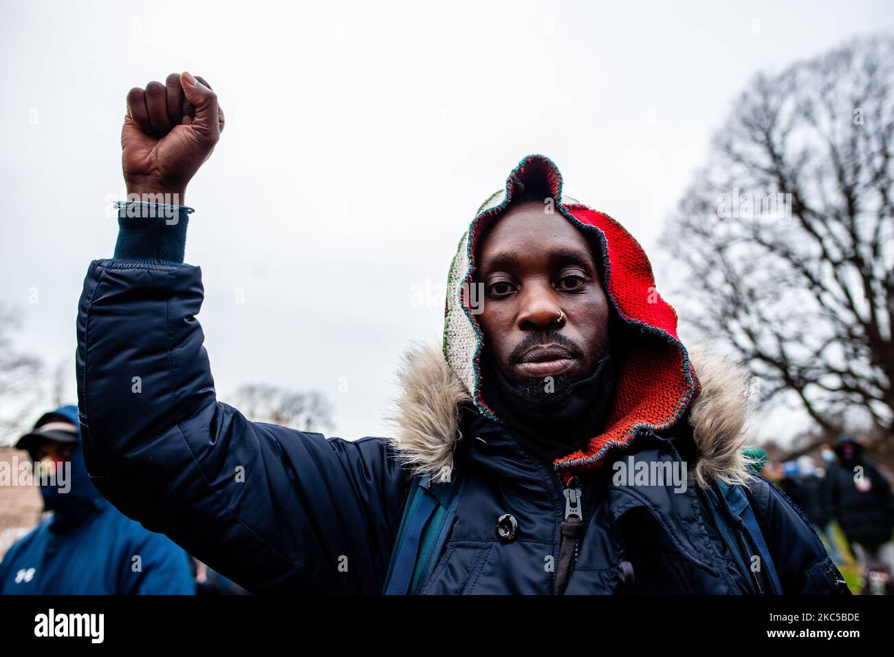 A Black man is seen raising his fist in the air as a symbol of Black 
