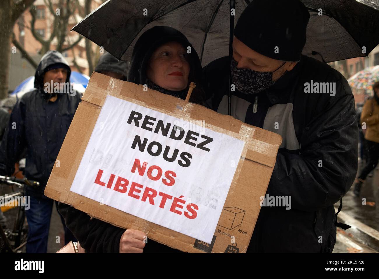 A couple of protesters hold a placard reading 'Give us back our freedoms'. Thousands protesters marched again against the 'Global Security Law' bill promoted by French President Macron and his majority and for more means for the public health system and hospitals. The 'Global Security Law' bill will forbid anyone to photograph or film police members if not flouted : transgressors could be condemned up to one year in jail and a €45.000 fine. The bill also plans to generalize facial recognition in pubic spaces as in China. The French Rights Defender, the French National Commission on Human Right Stock Photo