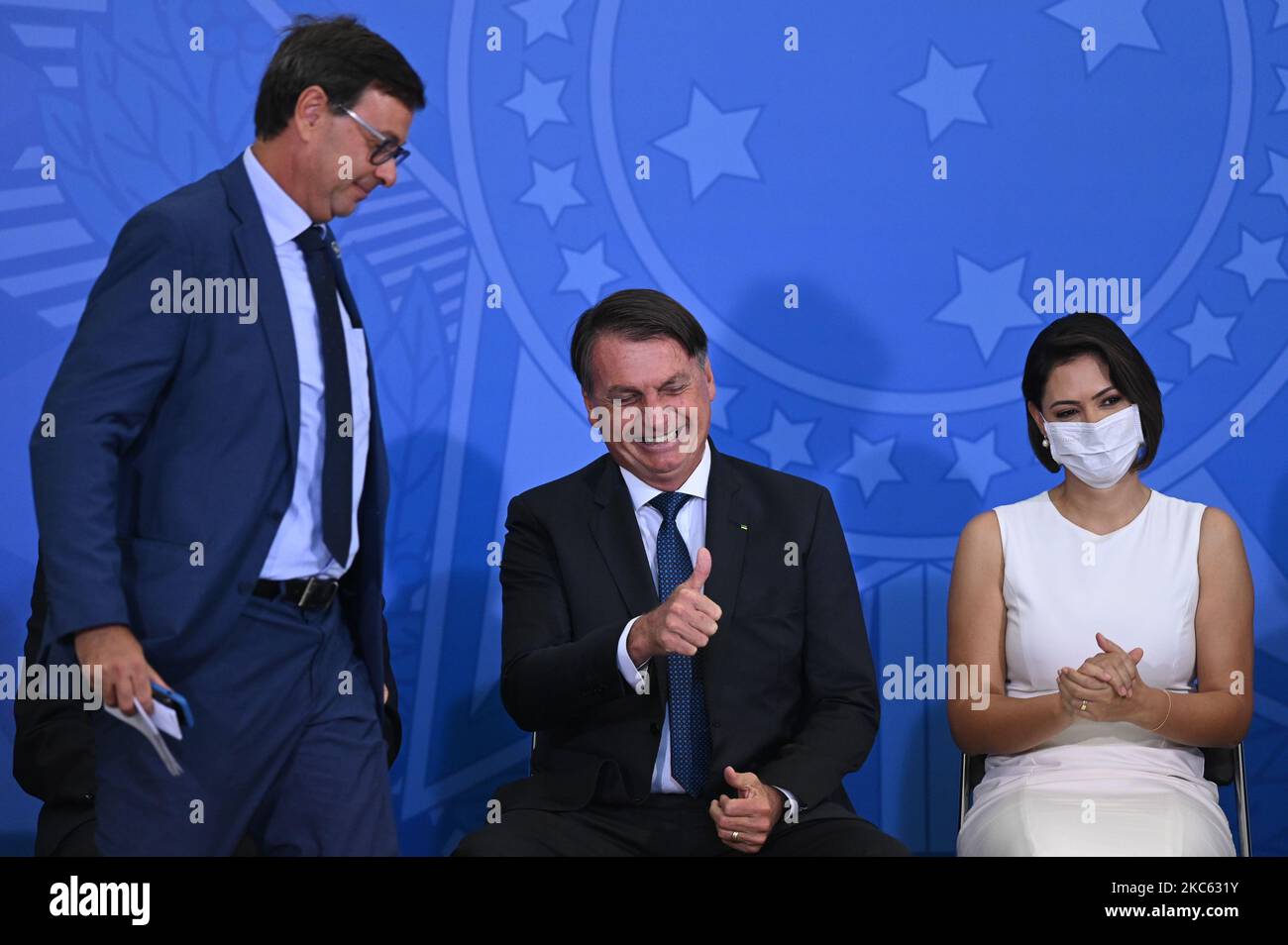 Brazil's President Jair Bolsonaro (center), next to Brazil's new Tourism minister Gilson Machado (left) and first lady Michelle Bolsonaro (right), reacts during the swearing-in ceremony of the Brazil's Tourism Minister Gilson Machado, amidst the Coronavirus (COVID - 19) pandemic at Planalto Palace on December 17, 2020 in Brasilia. (Photo by Andre Borges/NurPhoto) Stock Photo