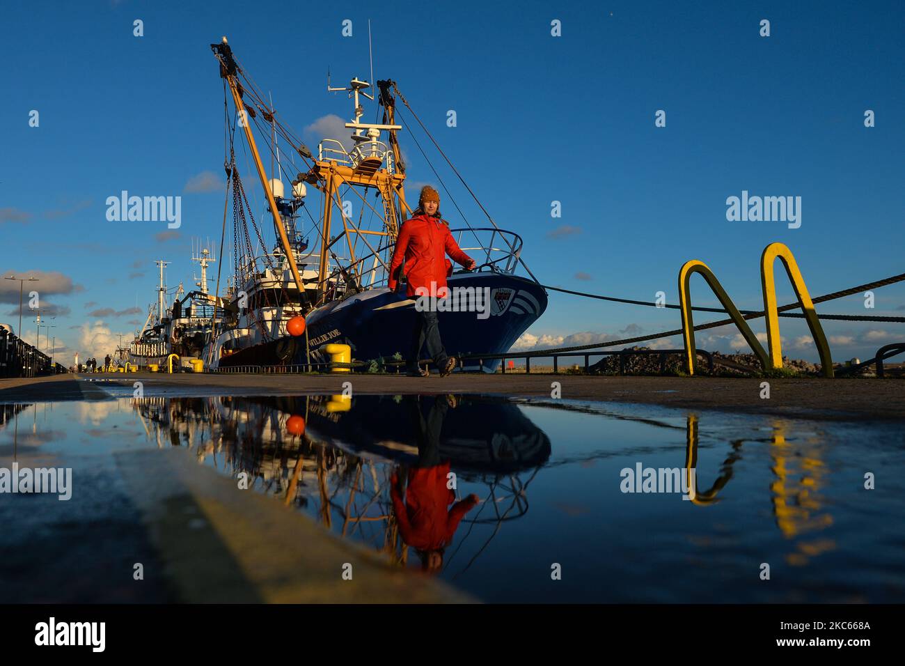 A woman walks by fishing boats moored in Howth Harbor. Following Brexit, the UK will no longer be part of the EU Commons Fisheries Policy (CFP). Becoming an independent coastal state it will be fully responsible for managing fisheries in the UK’s Exclusive Economic Zone of 200 miles (including setting total allowable catches, distributing quotas and determining access to fisheries). However, access for EU vessels to UK waters and vice versa is part of the ongoing negotiations and a future agreement with the EU. According to Patrick Murphy, chief executive of the Irish South and West Fish Produ Stock Photo