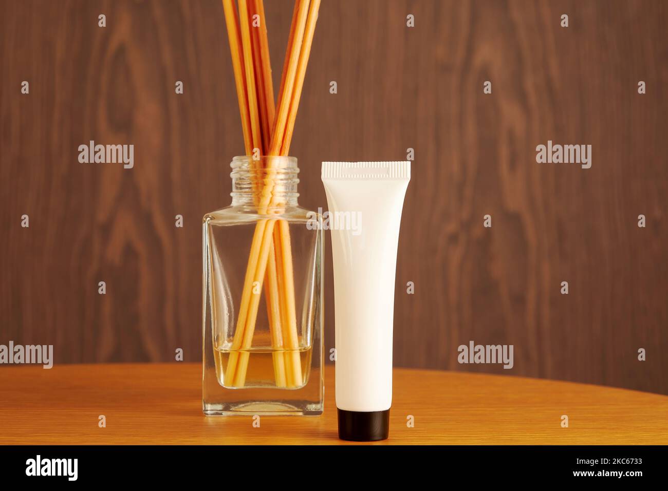 Plastic white beauty cosmetic bottle with aroma cream on the wooden table. White template with place for label. Copy space for advertisement Stock Photo