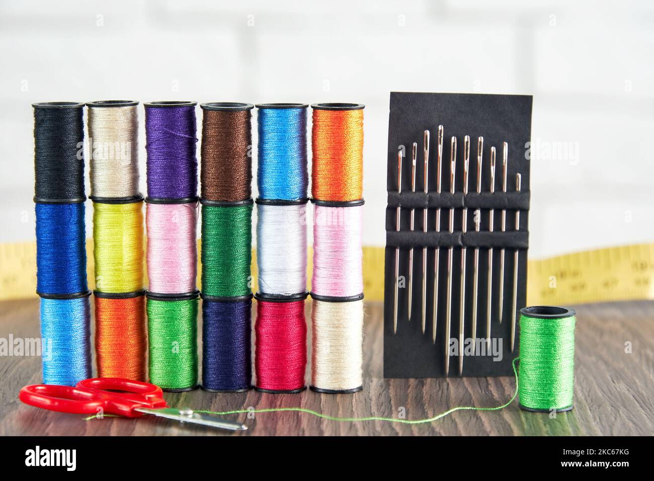 Rows of spools of colorful sewing threads and needlecraft accessories
