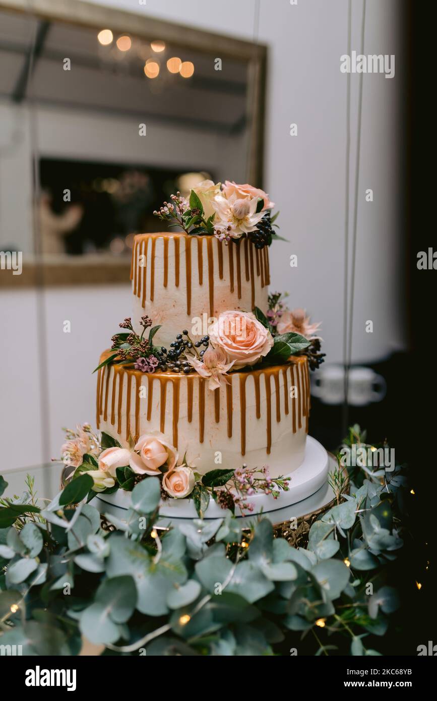 A vertical shot of a beautiful chocolate wedding cake with roses and leaves  decorating it Stock Photo - Alamy, image size:867x1390