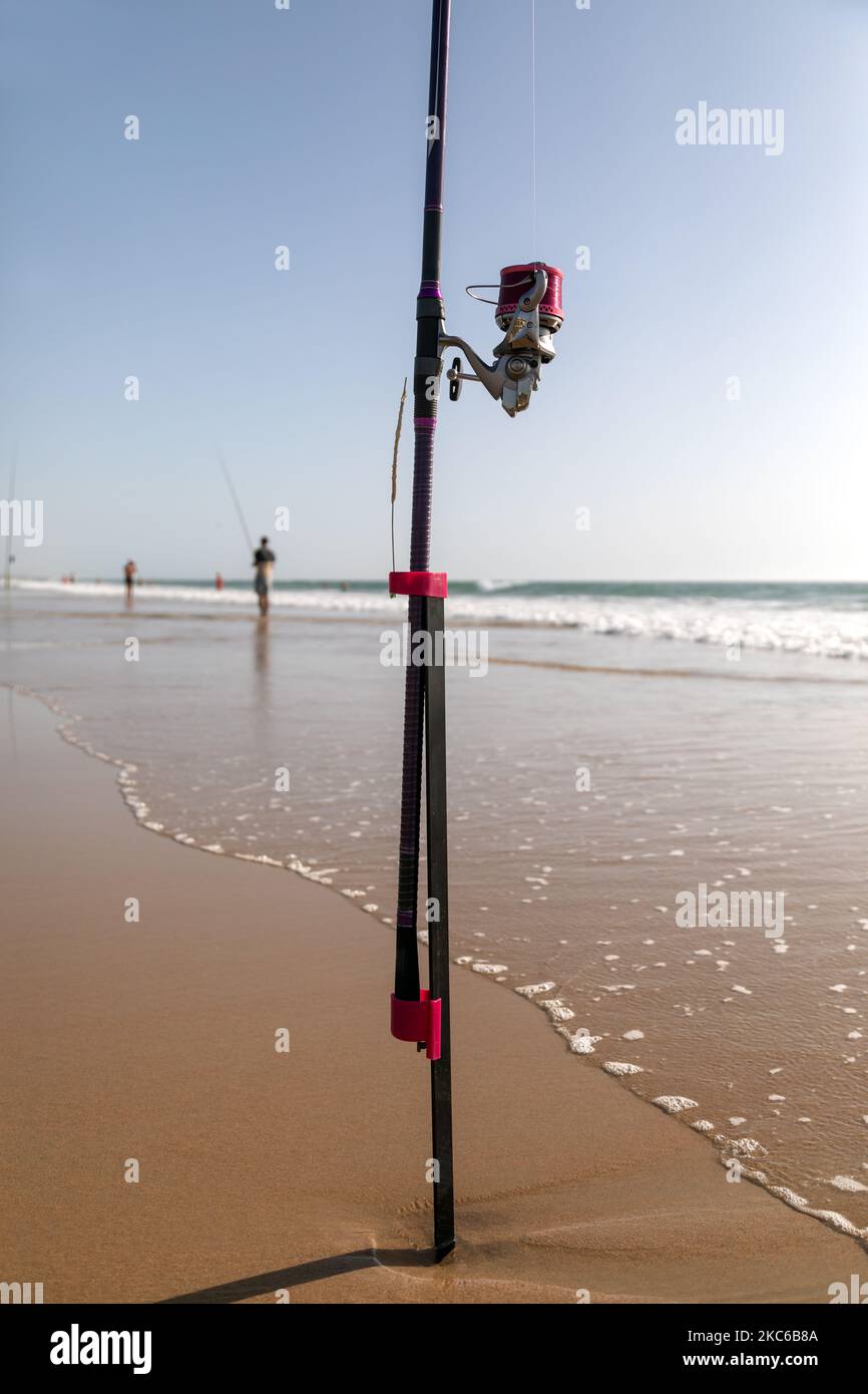 fishing rod stuck in the sand on the beach Stock Photo Alamy