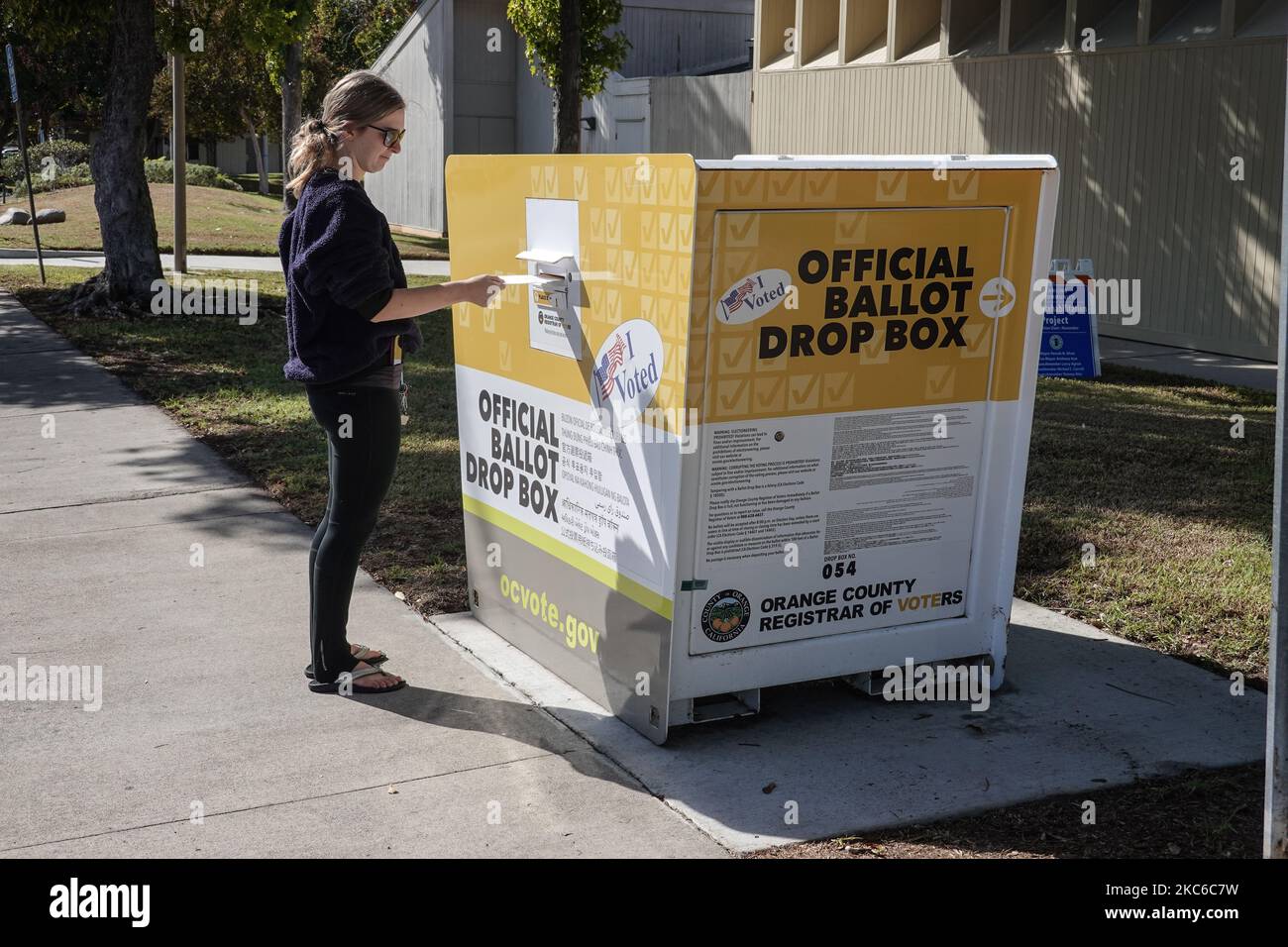 Young American woman casting her vote at ballot drop box for the 2022 US midterm Election in Irvine Orange County, California ;USA Stock Photo