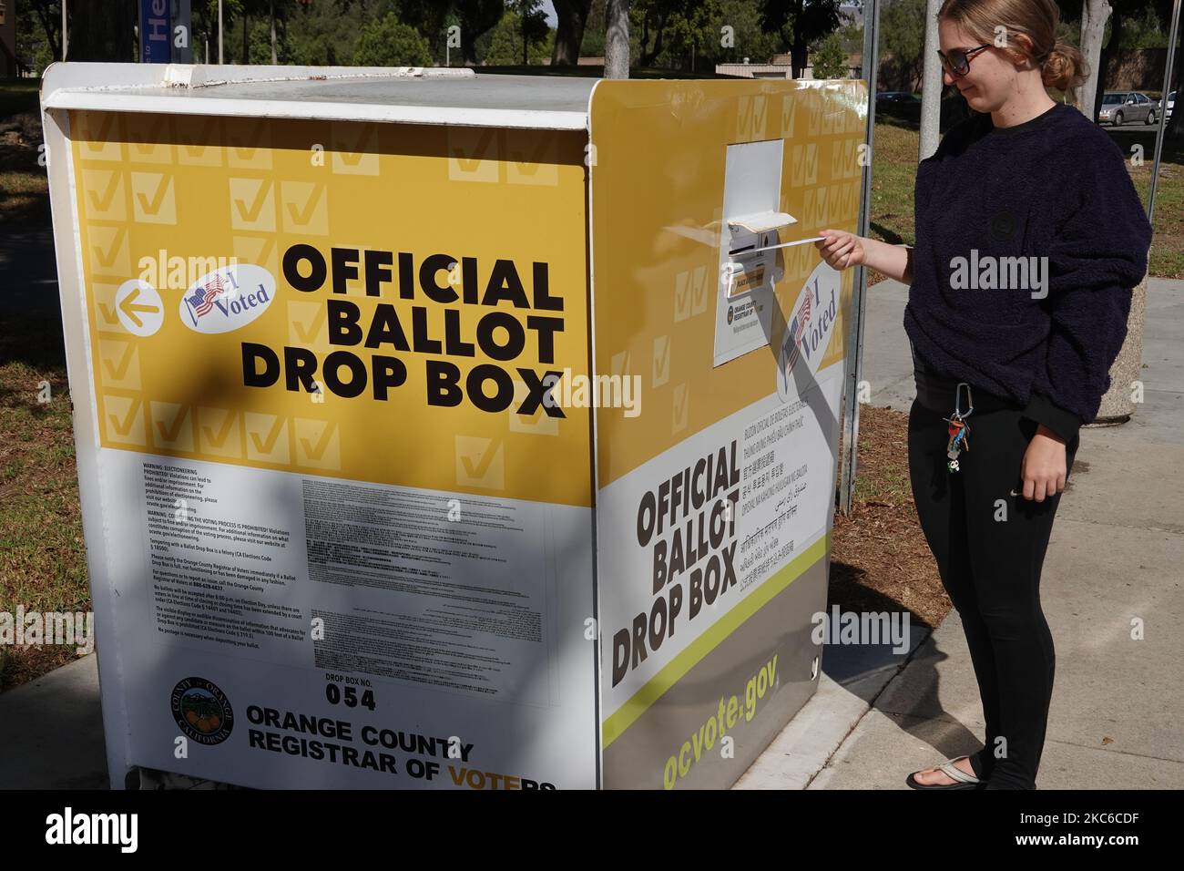 Young American woman casting her vote at ballot drop box for the 2022 US midterm Election in Irvine Orange County, California ;USA Stock Photo