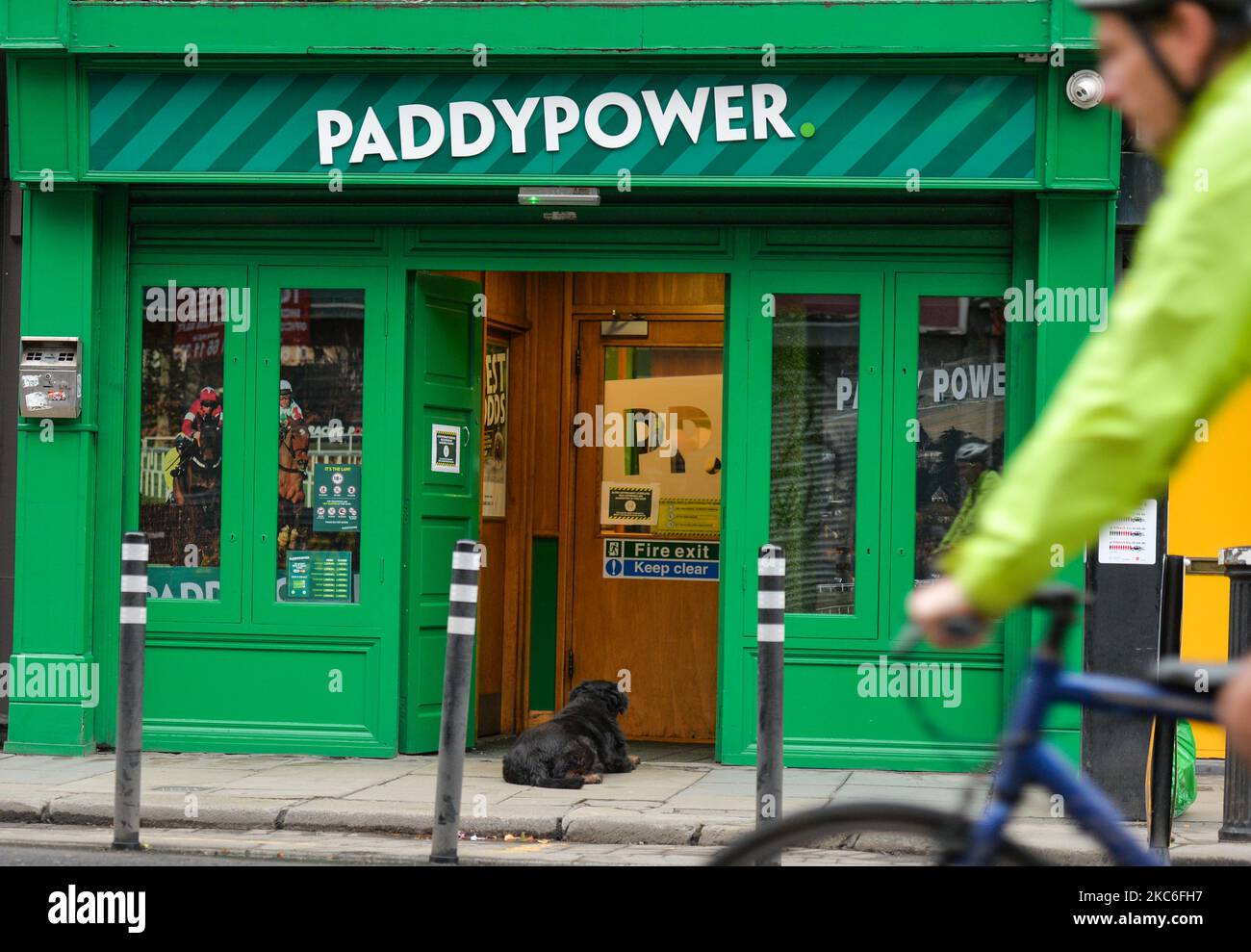 A dog awaits for his owner outside Paddy Power office in Dublin city centre on St. Stephen's Day. Taoiseach Micheal Martin announced on December 22nd a series of new Level 5 restrictions designed to contain the spread of the coronavirus. Among them are restrictions on the movement of people and the opening of all non-essential retail shops (shops may remain open but have to postpone January sales). The Department of Health reported today a new daily record of new cases for the Republic of Ireland, with 1,296 new cases and 6 deaths (2,294 new cases and 26 deaths confirmed on the island of Irela Stock Photo