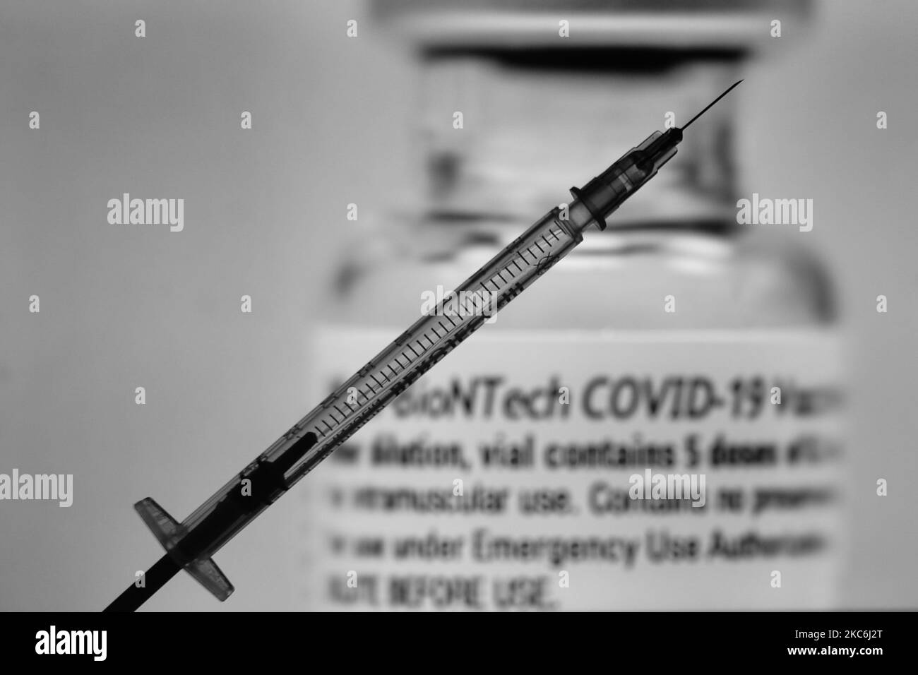 An illustrative image of a medical syringe in front of an image of a vial containing Pfizer-BionTech vaccine displayed on a screen. On Monday, December 28, 2020, in Dublin, Ireland. (Photo by Artur Widak/NurPhoto) Stock Photo