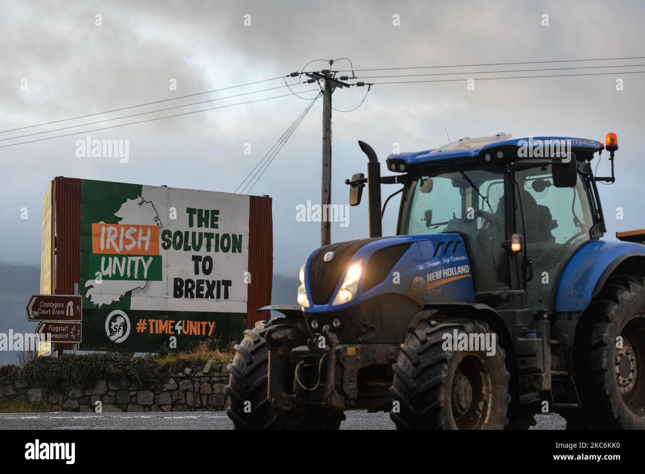 A tractor passes by a billborad 'Irish Unity The Solution To Brexit