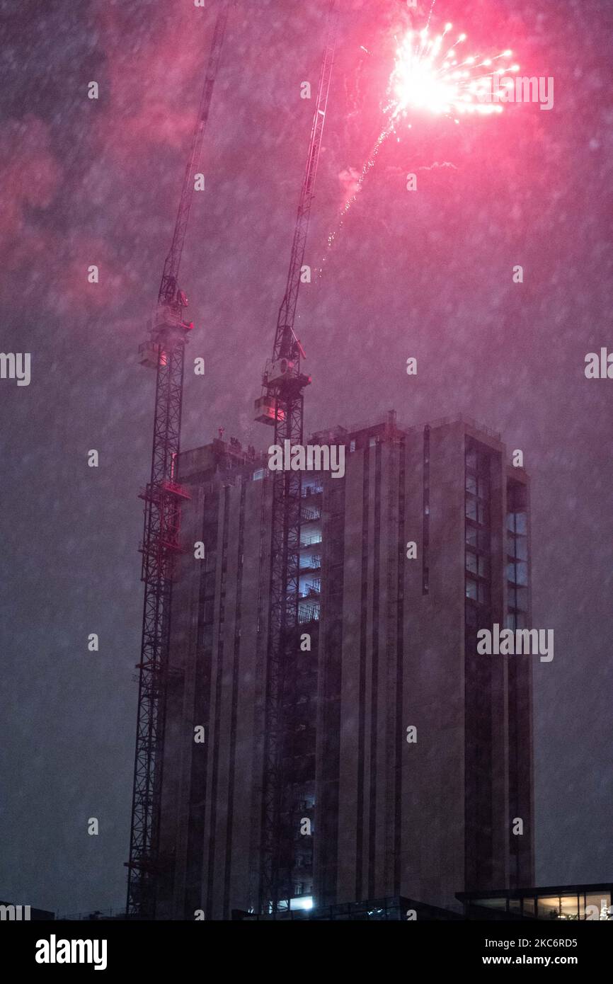 People set off fireworks from an unfinished block of apartments to