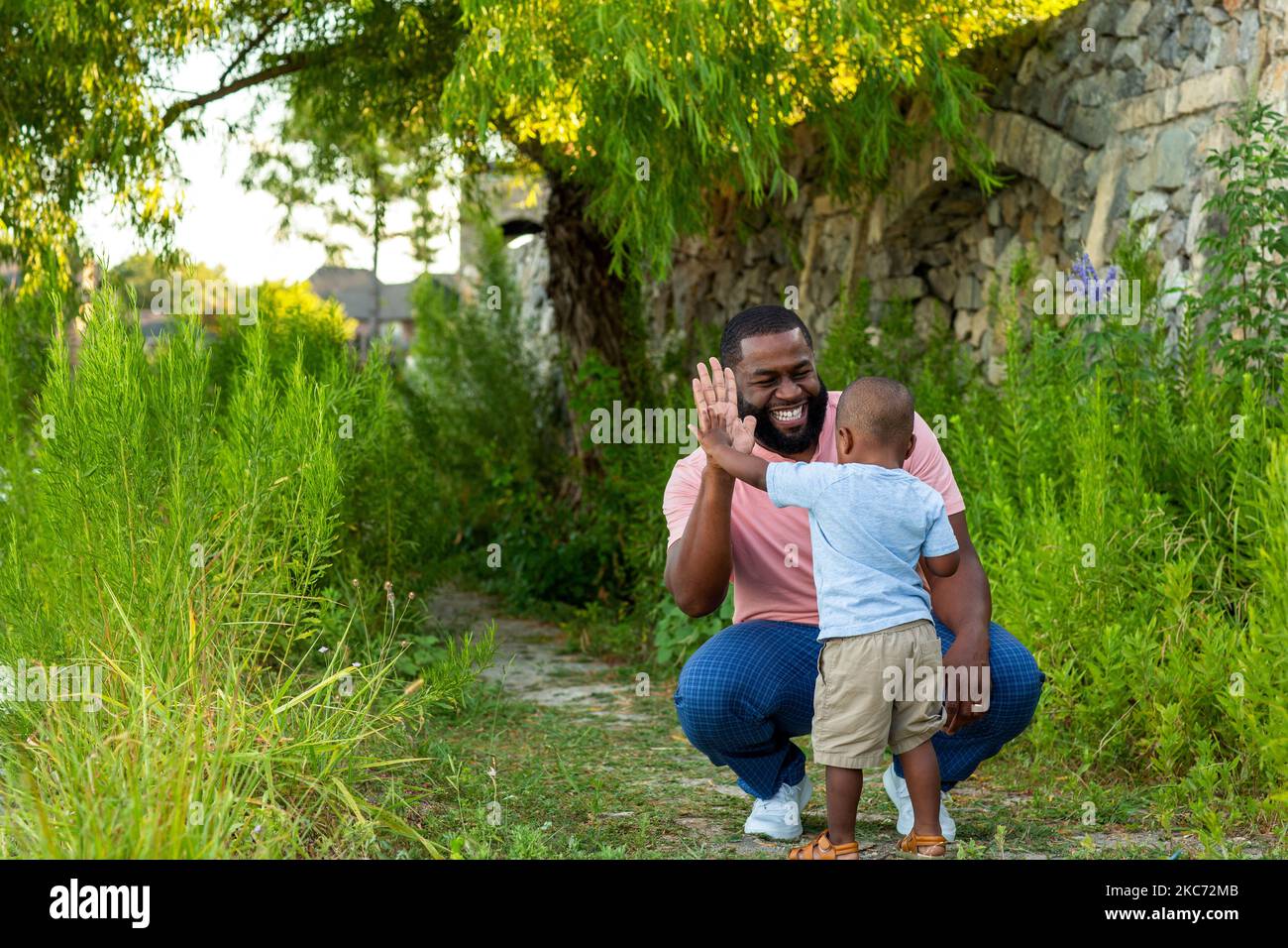 African American man playing and throwing rocks with his son Stock ...