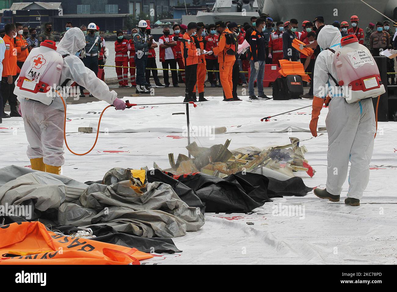 Officers spray disinfectant liquid to the Sriwijaya Air plane's debris was collected at the evacuation center located at Port of Tanjung Priok on January 10, 2021. The plane with 62 passengers with flight number SJ 182, which was scheduled to fly from Jakarta to Pontianak, crashed into the sea located in the north of Jakarta shortly after takeoff from Soekarno-Hatta airport on Saturday, January 9, 2021 (Photo by Eddy Purwanto/NurPhoto) Stock Photo