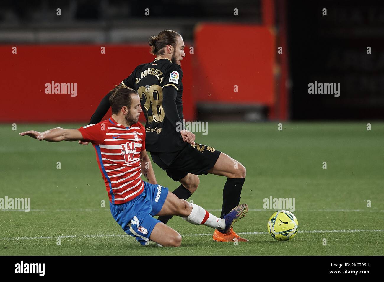 Oscar Mingueza of Barcelona and Roberto Soldado of Granada compete for the ball during the La Liga Santander match between Granada CF and FC Barcelona at Estadio Nuevo Los Carmenes on January 9, 2021 in Granada, Spain. Sporting stadiums around Spain remain under strict restrictions due to the Coronavirus Pandemic as Government social distancing laws prohibit fans inside venues resulting in games being played behind closed doors. (Photo by Jose Breton/Pics Action/NurPhoto) Stock Photo