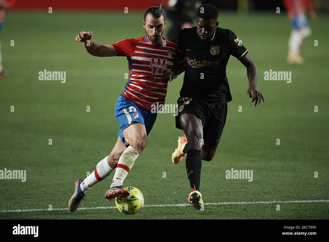 Roberto Soldado of Granada and Samuel Umtiti of Barcelona compete for the ball during the La Liga Santander match between Granada CF and FC Barcelona at Estadio Nuevo Los Carmenes on January 9, 2021 in Granada, Spain. Sporting stadiums around Spain remain under strict restrictions due to the Coronavirus Pandemic as Government social distancing laws prohibit fans inside venues resulting in games being played behind closed doors. (Photo by Jose Breton/Pics Action/NurPhoto) Stock Photo