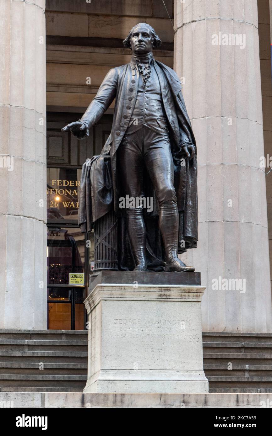 A bronze statue of the first President of the United States of America, George Washington, overlooks Wall Street and the New York Stock Exchange NYSE from the Federal Hall, the first capitol, in New York City. George Washington was inaugurated here as President in 1789 when NYC was the capital of the United States before it was moved in 1790 to Philadelphia, Pennsylvania. by John Quincy Adams Ward, installed on the front steps of Federal Hall National Memorial on Wall Street in New York City with the inscription at the base of the sculpture GEORGE WASHINGTON BORN FEBRUARY 22, 1732 WAKEFIELD WE Stock Photo