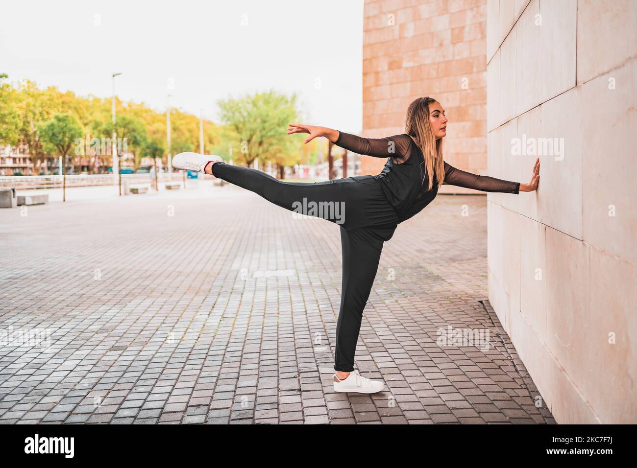 Slim woman doing yoga on street Stock Photo