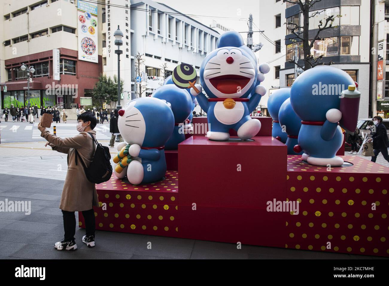 Man wearing a protective face mask takes his selfie with exhibit of cartoon characters at the shopping district in Tokyo, Japan on 16 January 2021. (Photo by Yusuke Harada/NurPhoto) Stock Photo