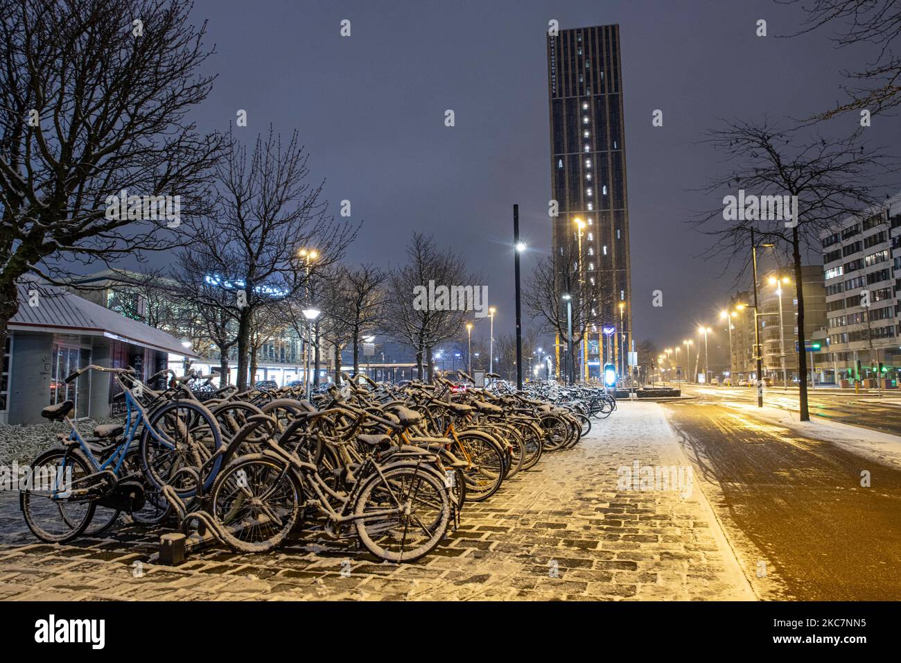 Thousands of bicycles covered by snow as seen parked near the train station. Night long exposure photography images of snow-covered and illuminated with city lights Eindhoven city center after the snowfall. Daily life in the Netherlands with the first snowfall of the year covering almost everything the cold weather shows subzero temperature. The chilly condition with snow and ice changed soon according to the forecast, the freezing condition will not last more than a day. Eindhoven, the Netherlands on January 16, 2020 (Photo by Nicolas Economou/NurPhoto) Stock Photo