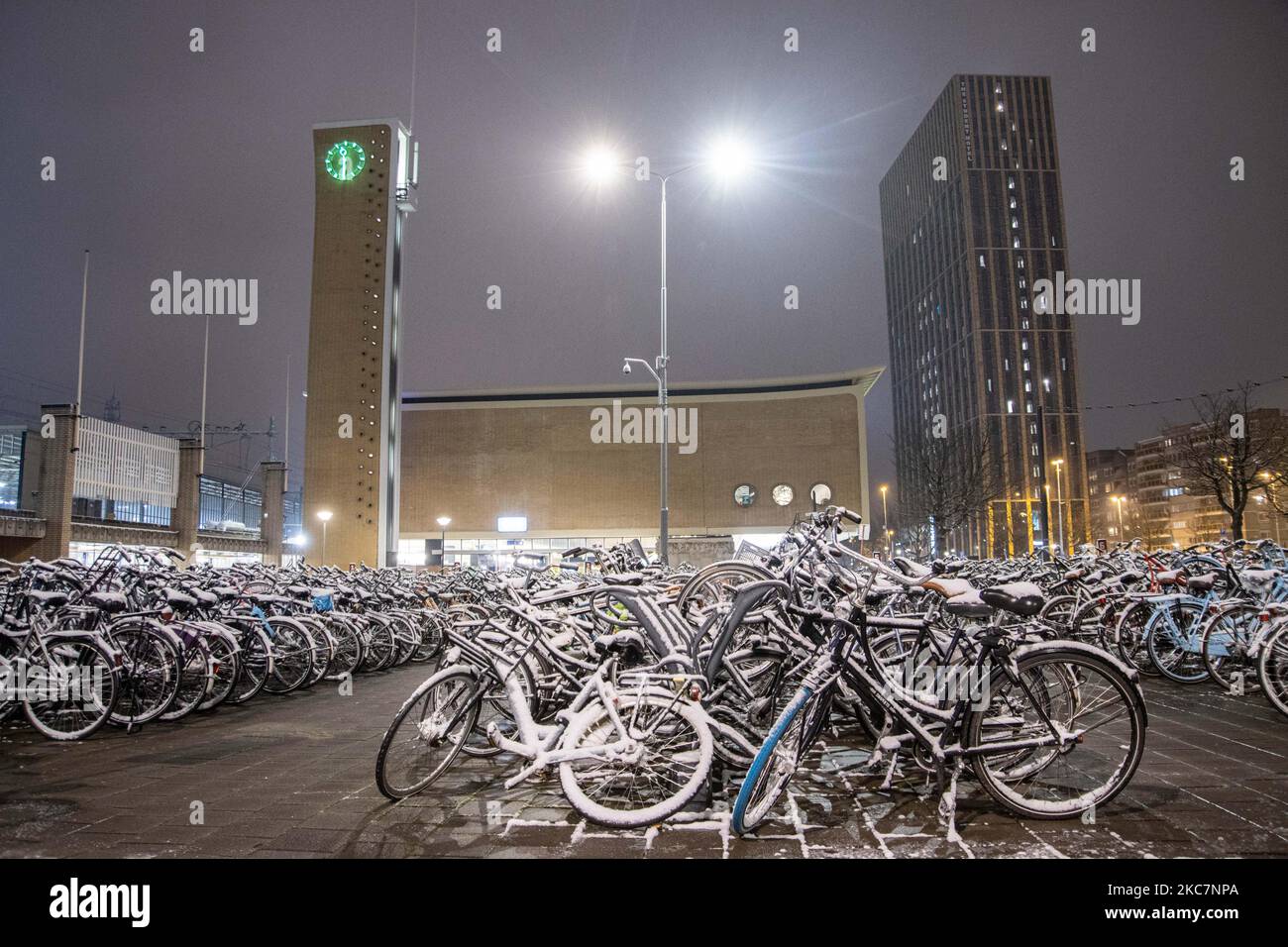 Thousands of bicycles covered by snow as seen parked near the train station. Night long exposure photography images of snow-covered and illuminated with city lights Eindhoven city center after the snowfall. Daily life in the Netherlands with the first snowfall of the year covering almost everything the cold weather shows subzero temperature. The chilly condition with snow and ice changed soon according to the forecast, the freezing condition will not last more than a day. Eindhoven, the Netherlands on January 16, 2020 (Photo by Nicolas Economou/NurPhoto) Stock Photo