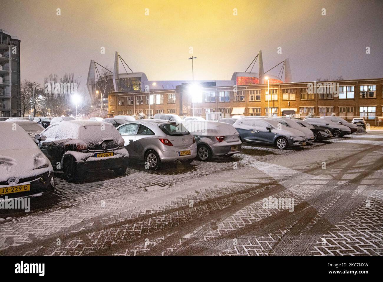 Snow covered vehicles in front of PSV Philips Stadion Stadium in Eindhoven during the night. Night long exposure photography images of snow-covered and illuminated with city lights Eindhoven city center after the snowfall. Daily life in the Netherlands with the first snowfall of the year covering almost everything the cold weather shows subzero temperature. The chilly condition with snow and ice changed soon according to the forecast, the freezing condition will not last more than a day. Eindhoven, the Netherlands on January 16, 2020 (Photo by Nicolas Economou/NurPhoto) Stock Photo