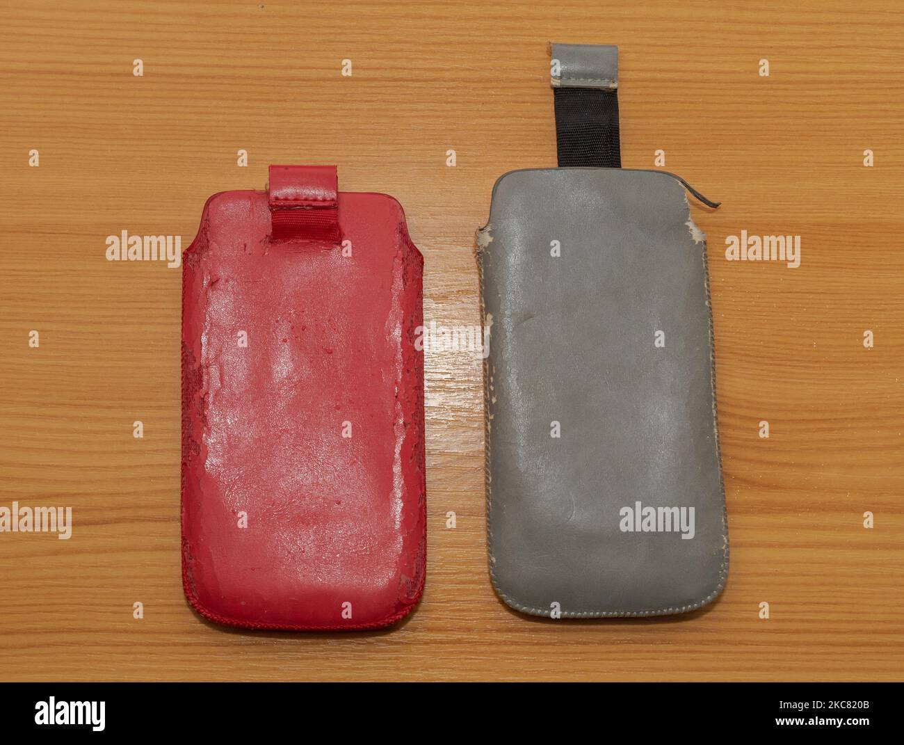 Ruined leather mobile phone cases isolated on wooden table surface Stock Photo