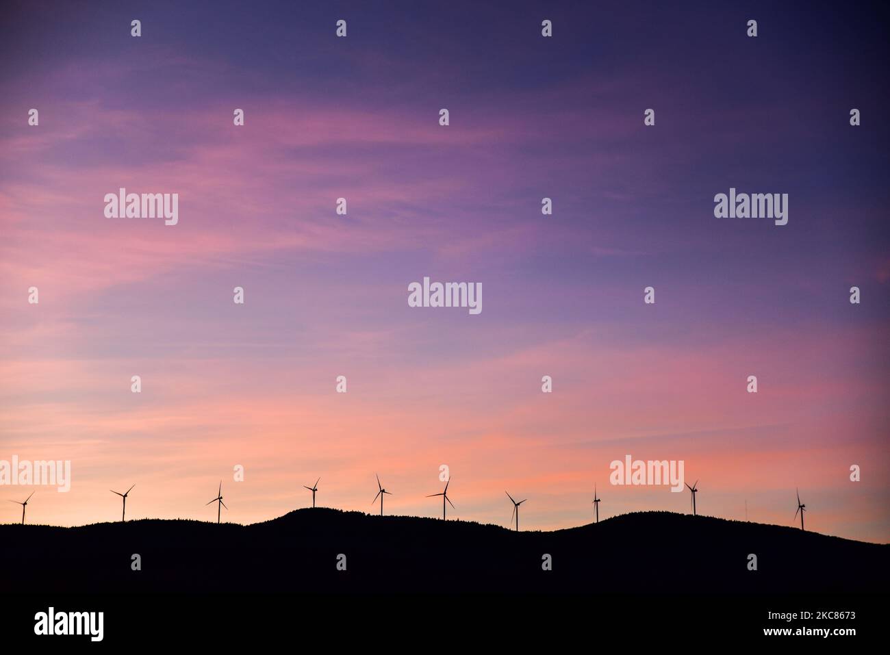 Silhouetted Vestas turbines, sunset, Green Mountain Power Corp. wind installation on Lowell