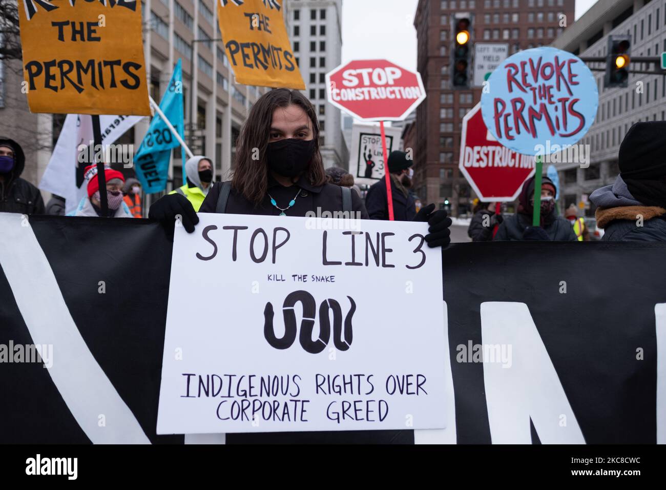 A protester displays a sign condemning Line 3 and corporate greed and demanding that treaty rights be respected. St. Paul, MN. January 29, 2021. Nearly 600 activists and water protectors took part in a protest against the Enbridge Line 3 pipeline on Friday evening in St. Paul, Minnesota. The event was organized by over a dozen groups, including Sunrise Movement MN, Honor the Earth, International Indigenous Youth Council, Environment MN, MN350, and others. Participants called for Governor Tim Walz as well as the Army Corp of Engineers to revoke the pipeline's permit on environmental safety and  Stock Photo