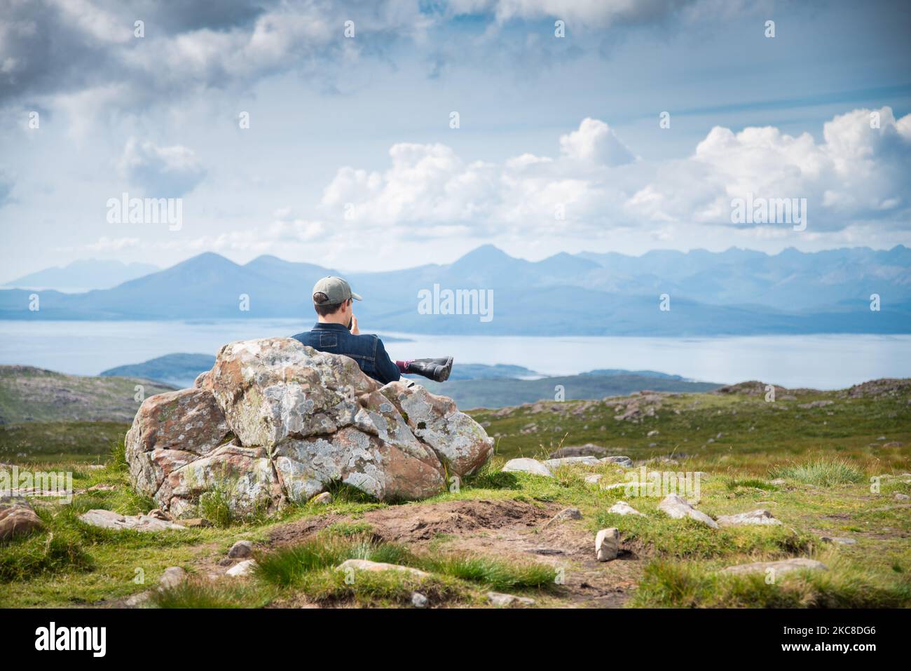 Applecross peninsula,Highlands of Scotland,UK-July 28 2022: A traveler and hiker,enjoys the mid summer views,from the top of the high mountain pass,ov Stock Photo