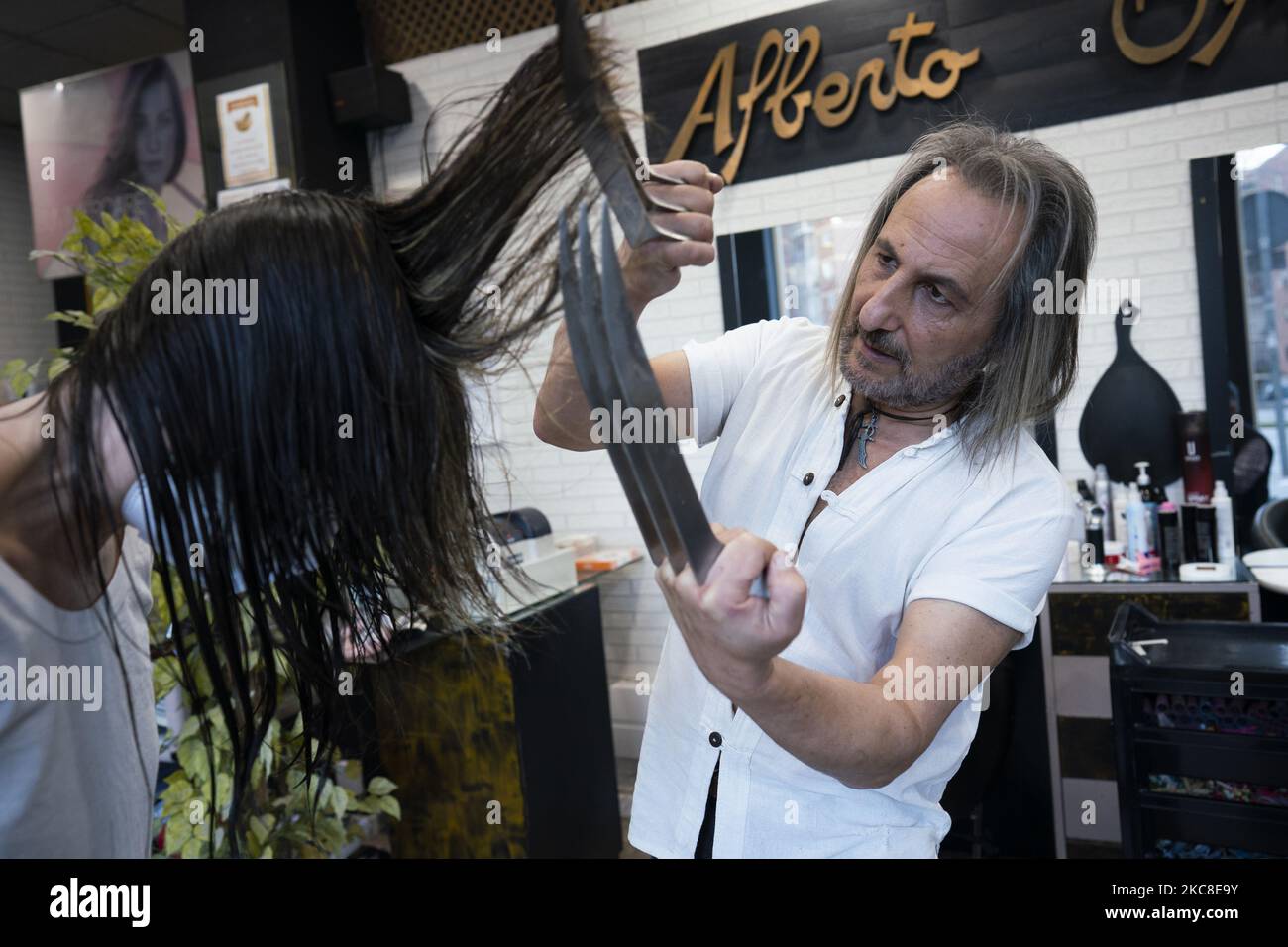 Hairdresser Alberto Olmedo demonstrates cutting a woman's hair using