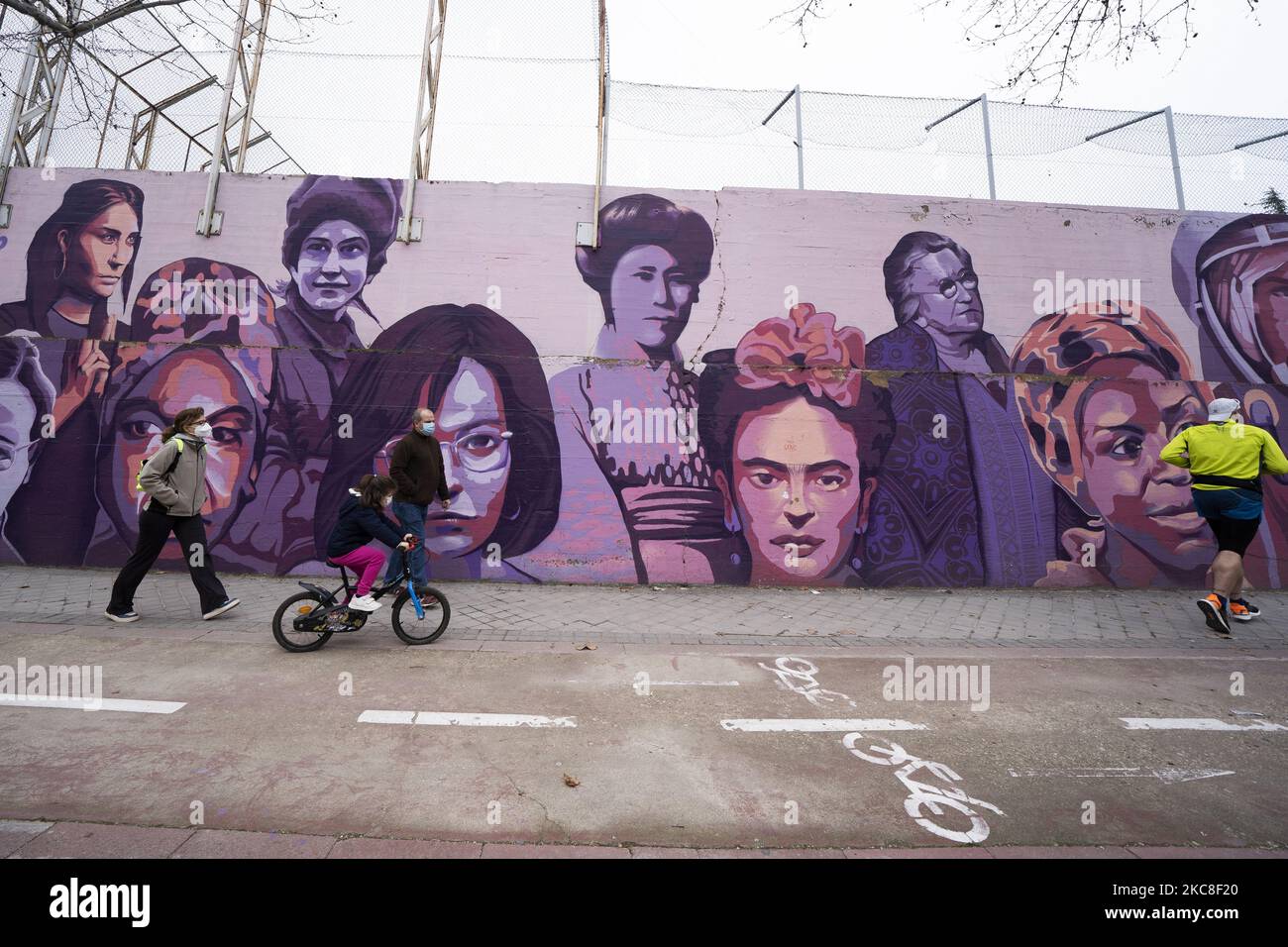 People walk past a mural in Madrid showing a diverse array of women from Nina Simone, and Rosa Parks to Frida Kahlo and the Red Army sniper Lyudmila Pavlichenko on January 31, 2021 in Madrid, Spain. The mural has been saved from destruction after city councillors stepped in to thwart far-right attempts to have it removed. (Photo by Oscar Gonzalez/NurPhoto) Stock Photo