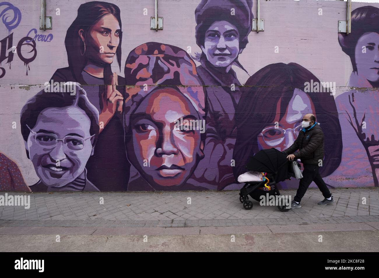 People walk past a mural in Madrid showing a diverse array of women from Nina Simone, and Rosa Parks to Frida Kahlo and the Red Army sniper Lyudmila Pavlichenko on January 31, 2021 in Madrid, Spain. The mural has been saved from destruction after city councillors stepped in to thwart far-right attempts to have it removed. (Photo by Oscar Gonzalez/NurPhoto) Stock Photo