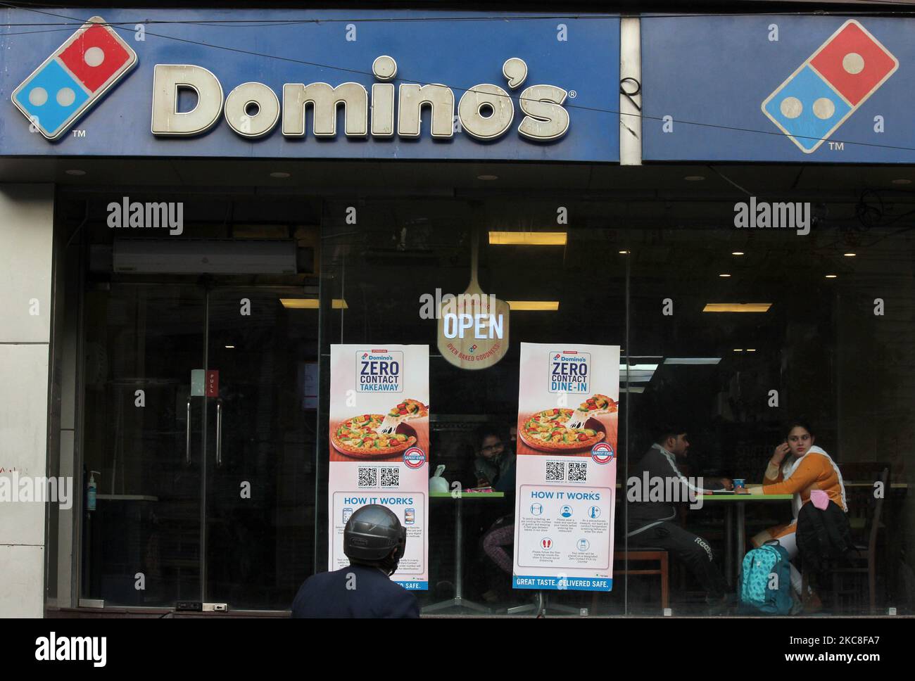 Customers eat at a Domino's Pizza outlet, in New Delhi on January 31, 2021. Food services company Jubilant FoodWorks Ltd (JFL), which runs Domino's Pizza and Dunkin Donuts, has entered the list of top 100 companies in India by average market cap for the period July-December 2020. (Photo by Mayank Makhija/NurPhoto) Stock Photo