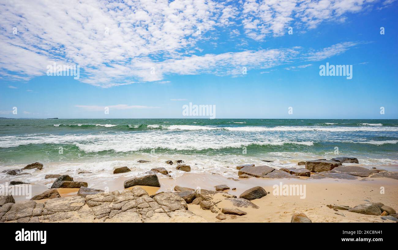 Looking out to the horizon of the Pacific Ocean from Alexandra Headland, Maroochydore. The sky is blue with inspiring white clouds, the ocean water is Stock Photo