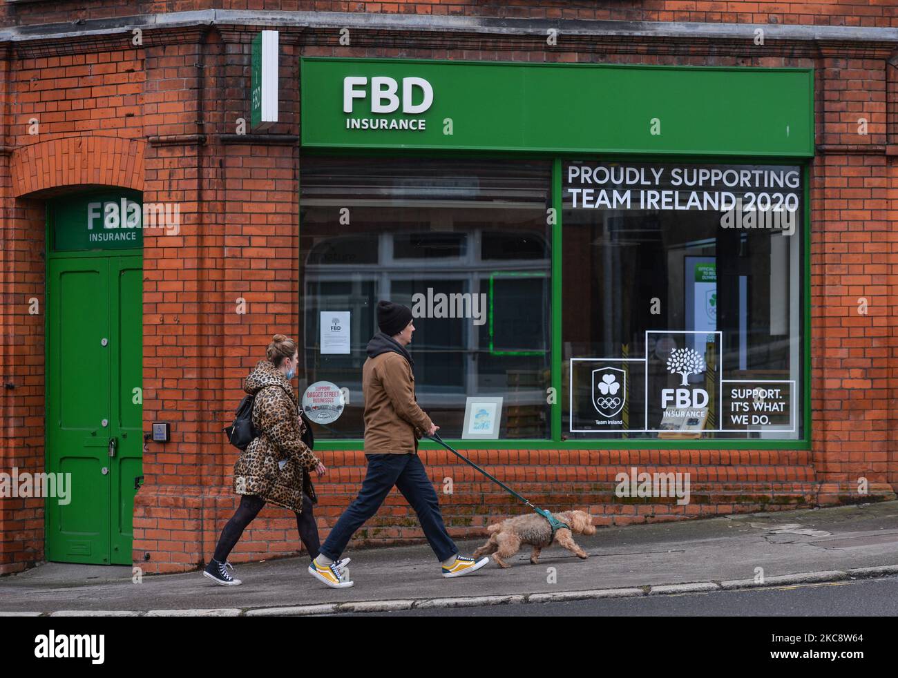 People walking by an FBD Insurance branch in Dublin city center during Level 5 Covid-19 lockdown. The High Court has ruled that three Dublin pubs amd one from Athlone are entitled to be compensated by FBD Insurance for the disruption their businesses suffered due to the Covid-19 pandemic. On Saturday, February 6, 2021, in Dublin, Ireland. (Photo by Artur Widak/NurPhoto) Stock Photo