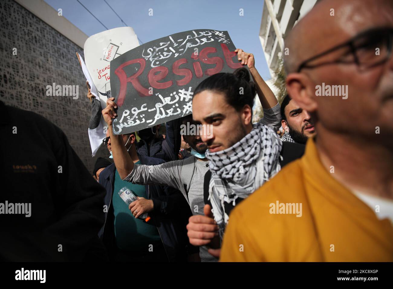 A young Tunisian protesters lifts a placard that reads ‘resist’ as he took part in a march held towards avenue Habib Bourguiba in the capital Tunis in commemoration of the 8th anniversary of the assassination of the leftist opposition politician Chokri Belaid to call for uncovering the truth about the assassination of Chokri Belaid. Demonstrators also protested against police repression and demanded the release of young people arrested by the security forces. Some young protesters called for the decriminalization of Cannabis and soft drugs, and some others called for the fall of the government Stock Photo