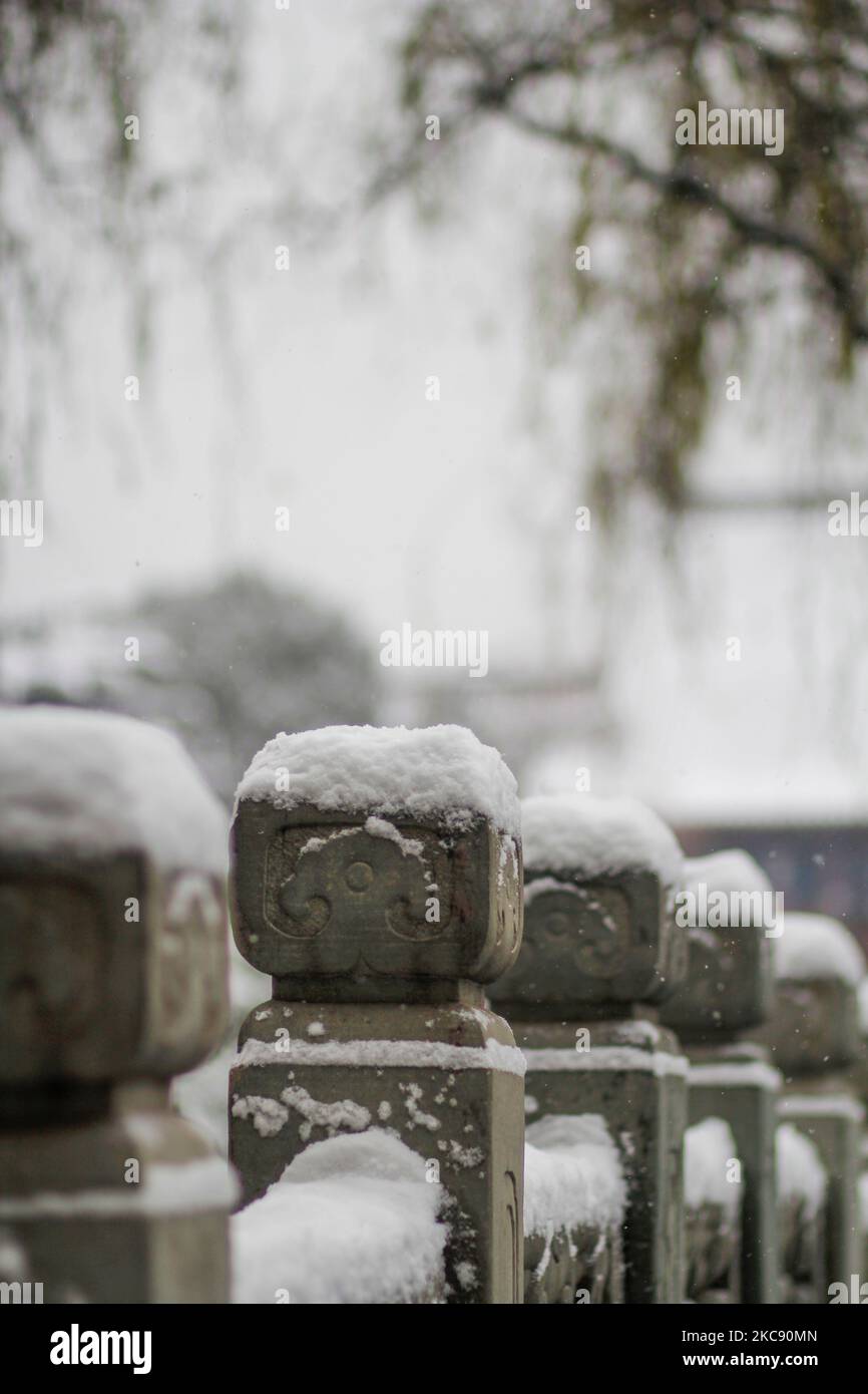 A vertical shot of a stone fence with columns covered in snow Stock ...