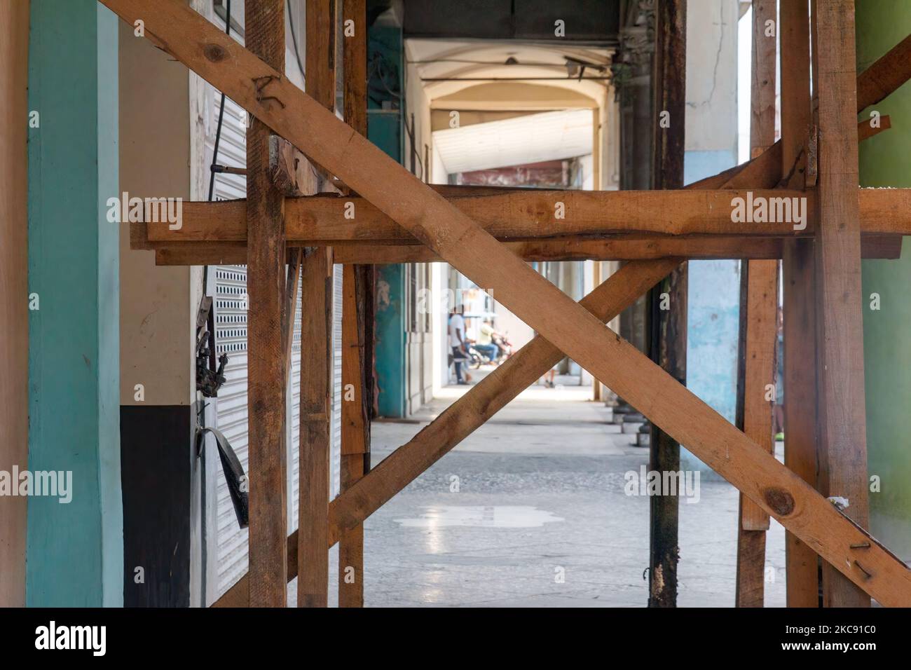 A wood support beam structure prevents a building porch from collapsing. Stock Photo
