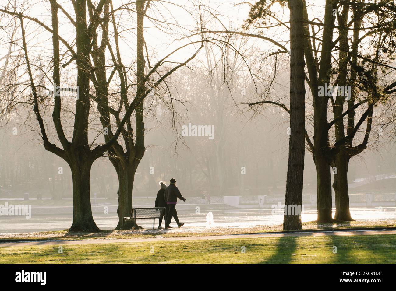 people walk in the Hiroshima Nagasaki park in Cologne as the chilly temperatures will continues