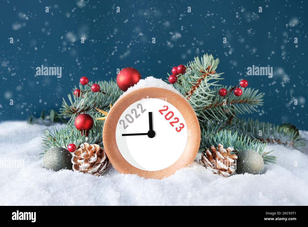 Year 2022 changes to 2023. Wood alarm clock with fir twigs, cones, red