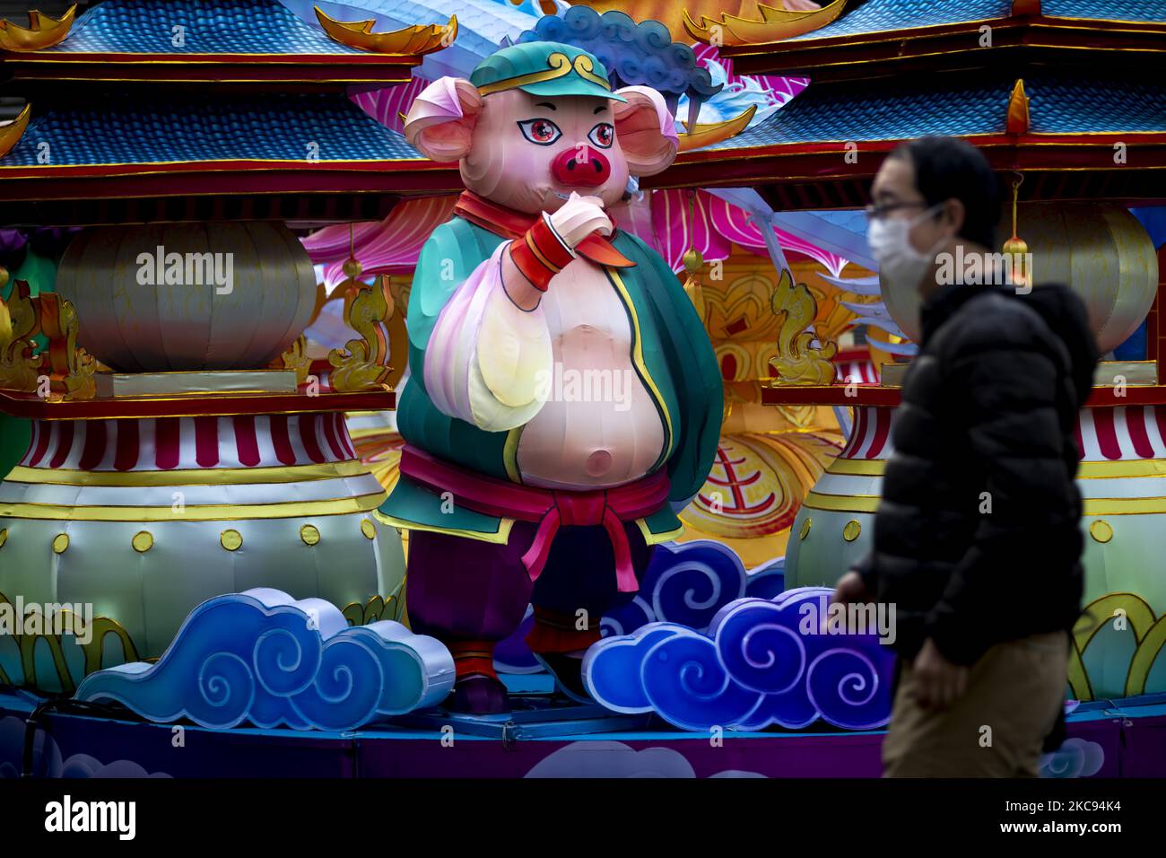 A man wearing a protective mask walks past at Lanterns featuring 'Journey to the West' are displayed at Yamashitacho Park during the lunar new year on February 12, 2021 in Yokohama, Japan. Yokohamas Chinatown, the largest in Japan, has imposed restrictions on celebrations marking lunar new year a cause of Covid-19. (Photo by Alessandro Di Ciommo/NurPhoto) Stock Photo
