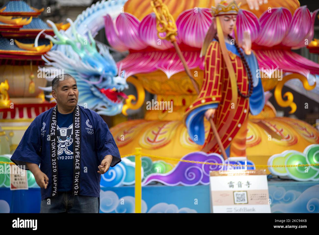A man wearing olympic T-shirt in front of Lanterns featuring 'Journey to the West' are displayed at Yamashitacho Park during the lunar new year on February 12, 2021 in Yokohama, Japan. Yokohamas Chinatown, the largest in Japan, has imposed restrictions on celebrations marking lunar new year a cause of Covid-19. (Photo by Alessandro Di Ciommo/NurPhoto) Stock Photo