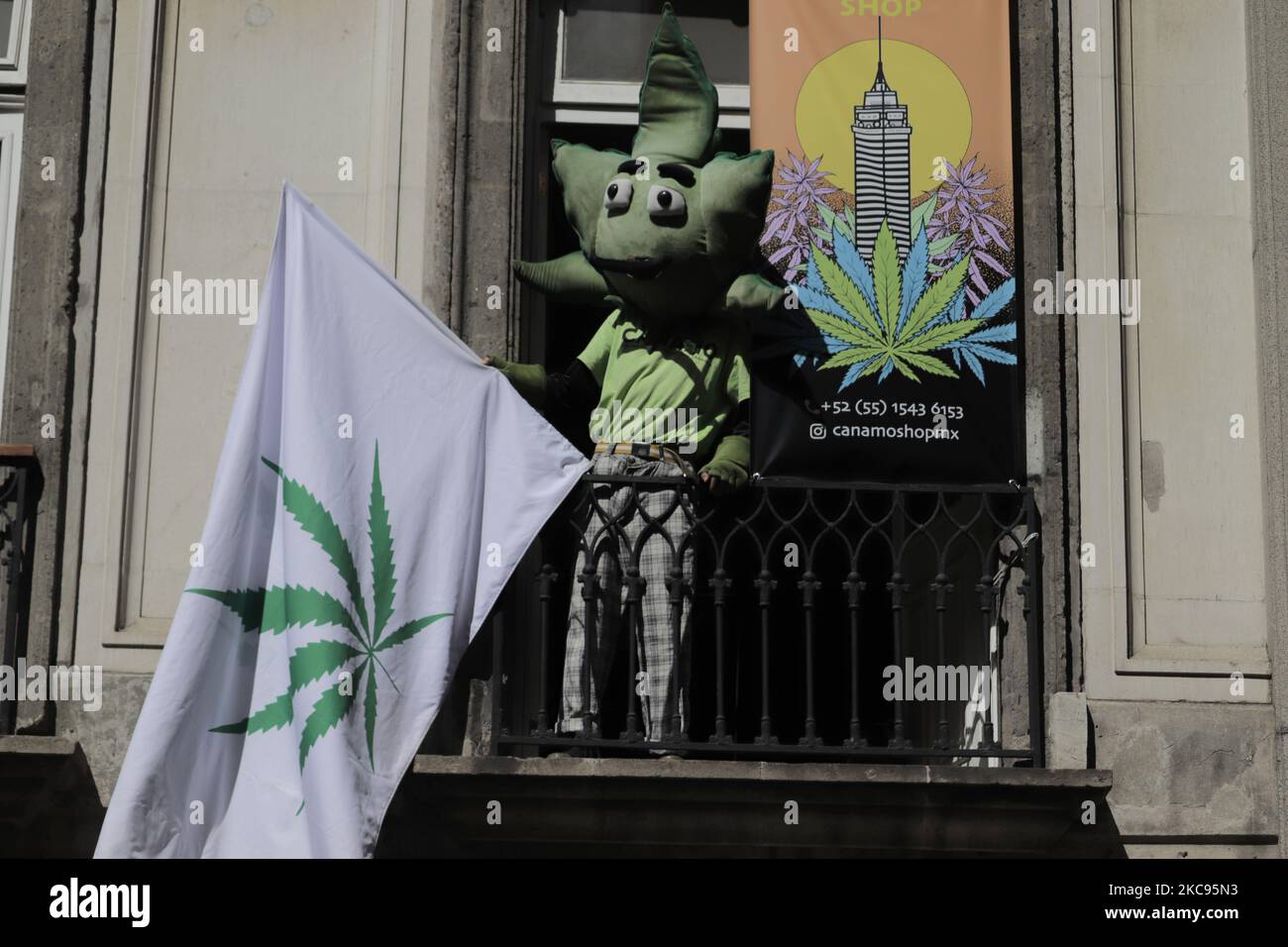 A person disguised as a marijuana leaf from a balcony of a store in the Historic Center of Mexico City, during the announcement of the capital authorities about the return to the orange epidemiological traffic light from Monday, February 15, during the health emergency due to COVID- 19 and the decrease in hospital occupancy. (Photo by Gerardo Vieyra/NurPhoto) Stock Photo