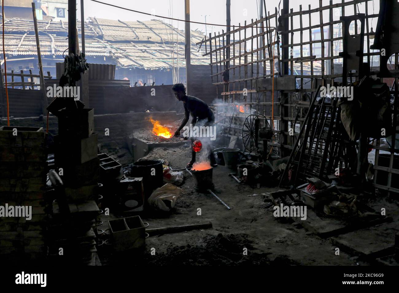 A Bangladeshi worker helps to melt iron on a furnace as he works at a