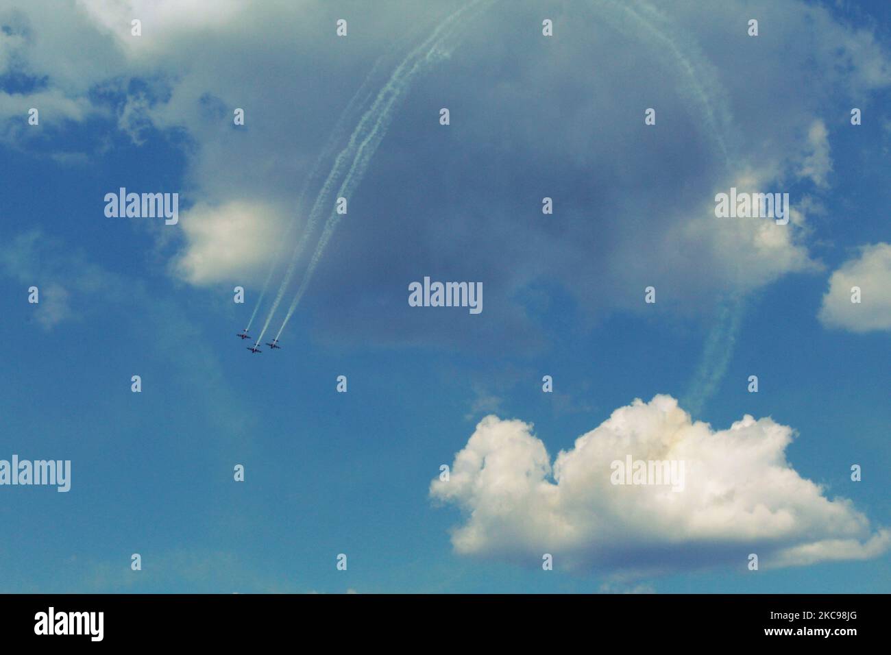 A beautiful cloudy blue sky with three airplanes during the air show with white smoke trails Stock Photo