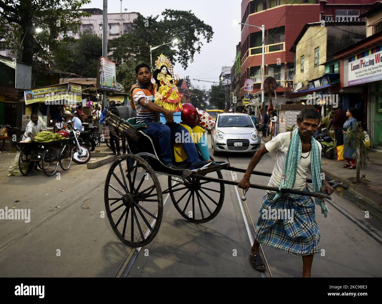 A rickshaw puller carries his passenger with Saraswati goddess in Kolkata, 15 February, 2021. Basant Panchami, which will be celebrated on 16 February this year, marks the advent of spring. (Photo by Indranil Aditya/NurPhoto) Stock Photo