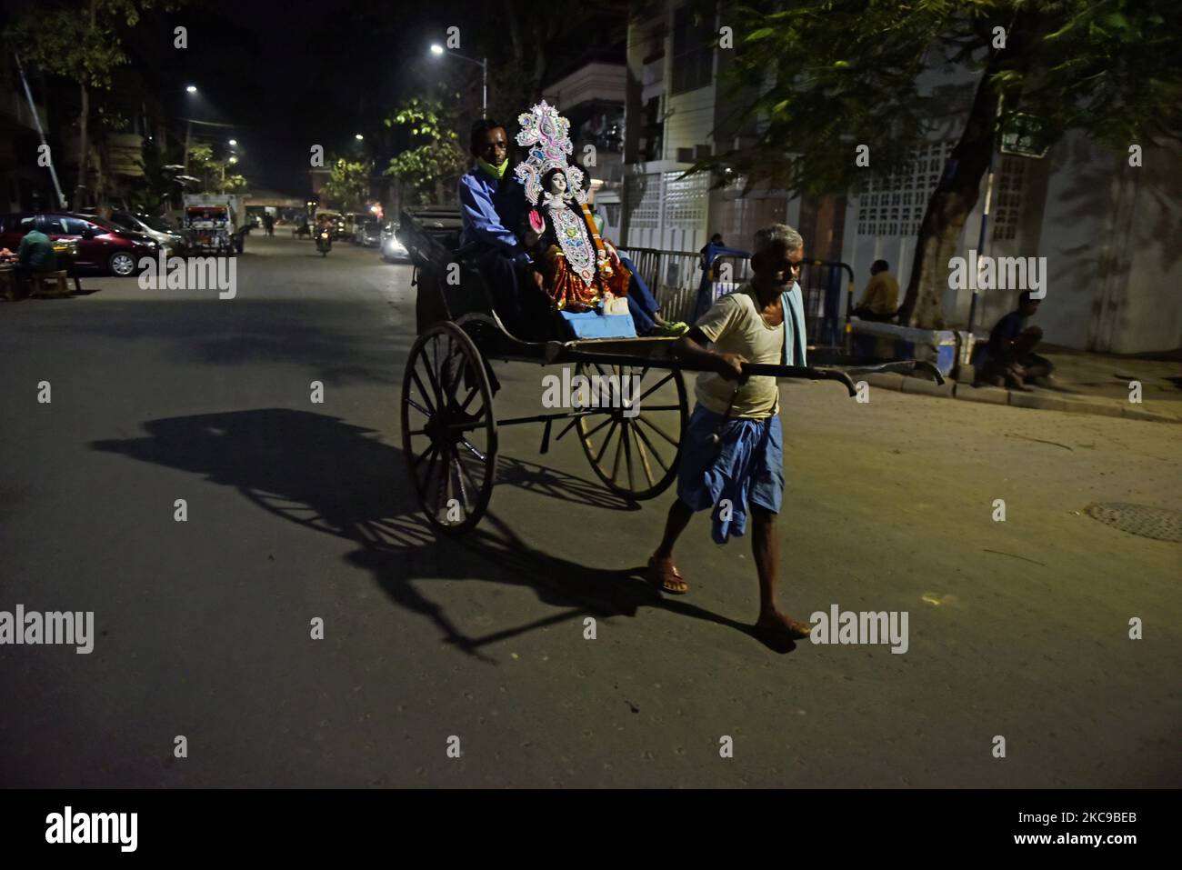 A rickshaw puller carries his passengers with Saraswati goddess in Kolkata, 15 February, 2021. Basant Panchami, which will be celebrated on 16 February this year, marks the advent of spring. (Photo by Indranil Aditya/NurPhoto) Stock Photo