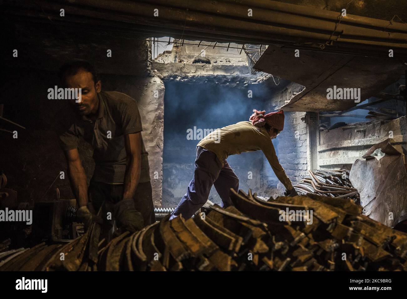 Bangladeshi rolling mill worker seen working in the steel re-rolling mill without proper safety gear or tools in Postagola, Bangladesh on February 15, 2021. In these mills iron is forged in 1200 + to 1300+ Celsius. In such a heated place the soles of their shoes are likely to be burnt off with one careless step. (Photo by Ahmed Salahuddin/NurPhoto) Stock Photo