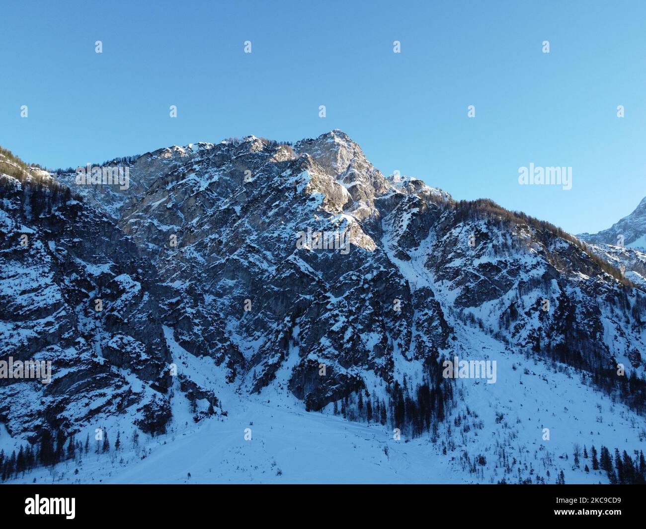 An aerial view of snow covered mountains under blue bright sky Stock ...